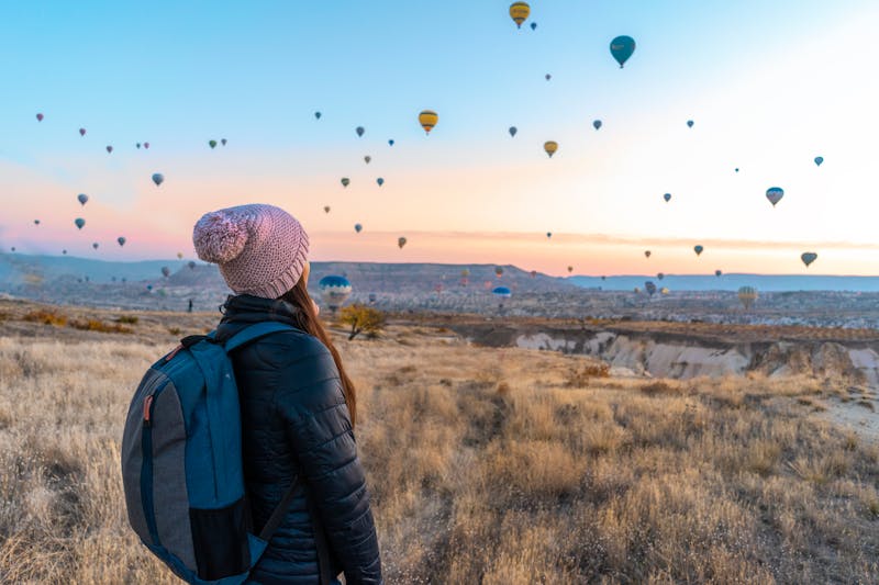 Viajero solitario con mochila contemplando un paisaje durante su primer viaje solo